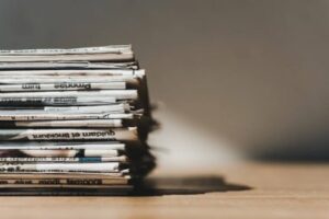 depositphotos_258955098-stock-photo-different-print-newspapers-pile-wooden